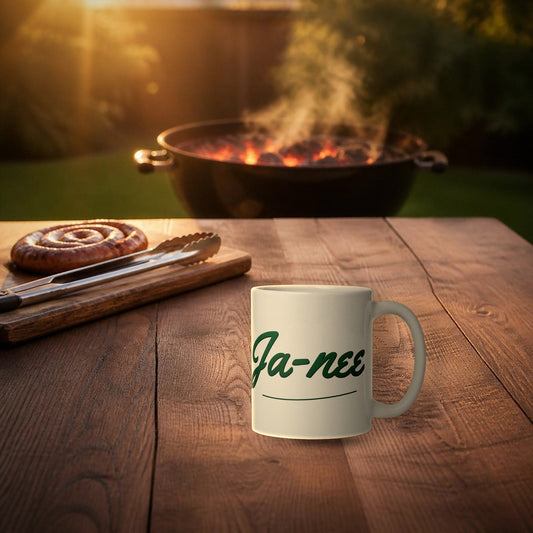 Ja-nee Mug – white ceramic mug with Afrikaans 'Ja-nee' print on a braai table at golden hour
