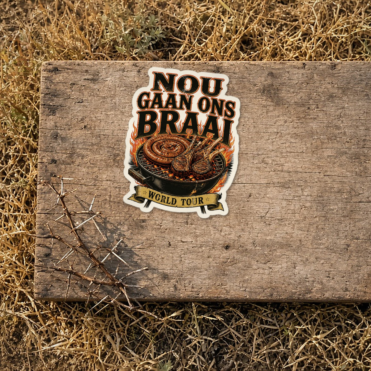 Nou Gaan Ons Braai sticker on a weathered wooden camp box lid in the bushveld – 'World Tour' braai grill vinyl sticker
